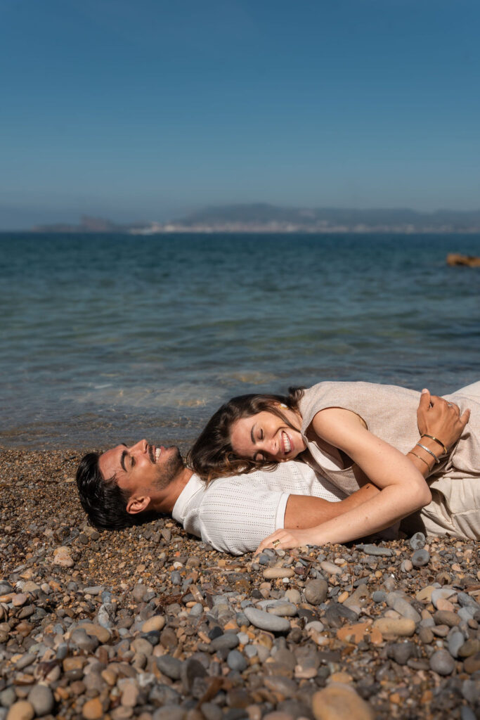 seance photo couple allege sur les galets au bord de la mer